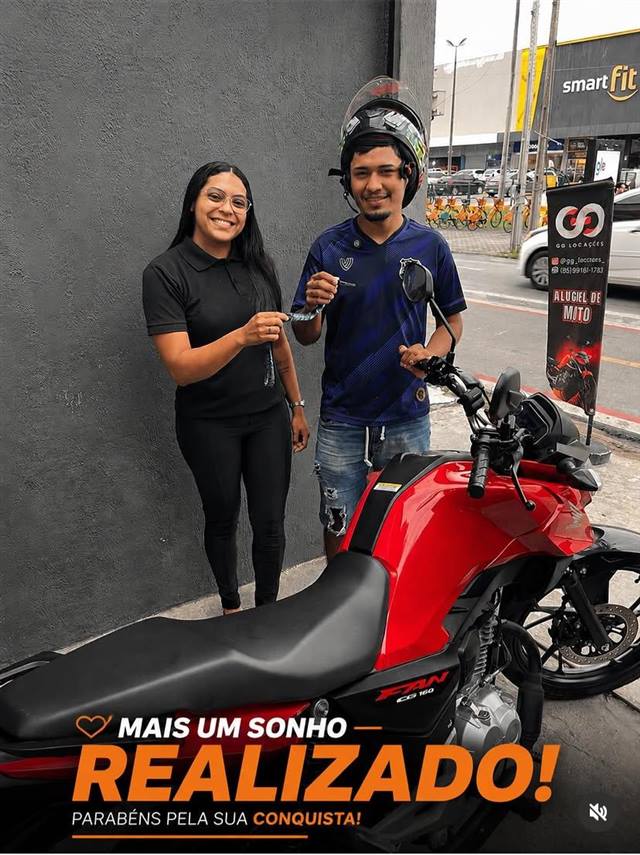 Cliente da GG Locações recebendo a chave da moto Fan 160, sonho realizado
